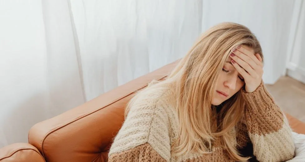 Woman at home holding her head during a migraine