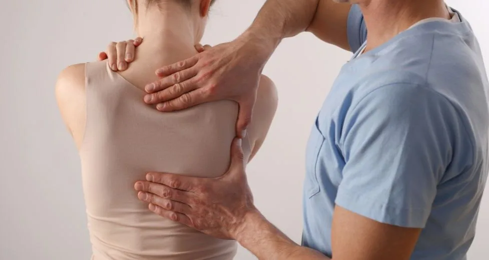 Practitioner assessing a patient’s spinal alignment