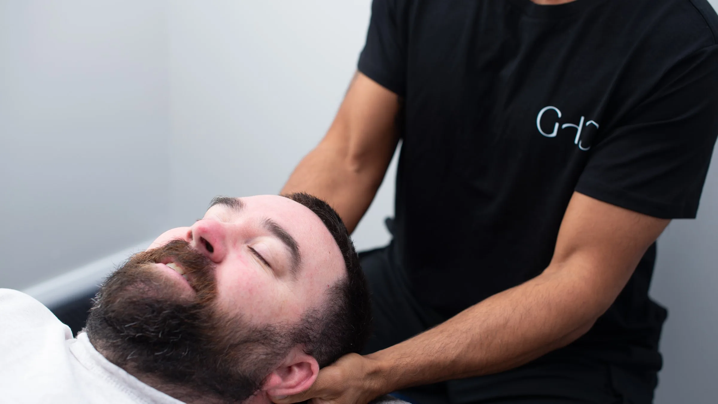 Physiotherapist cradling a patient’s neck during treatment