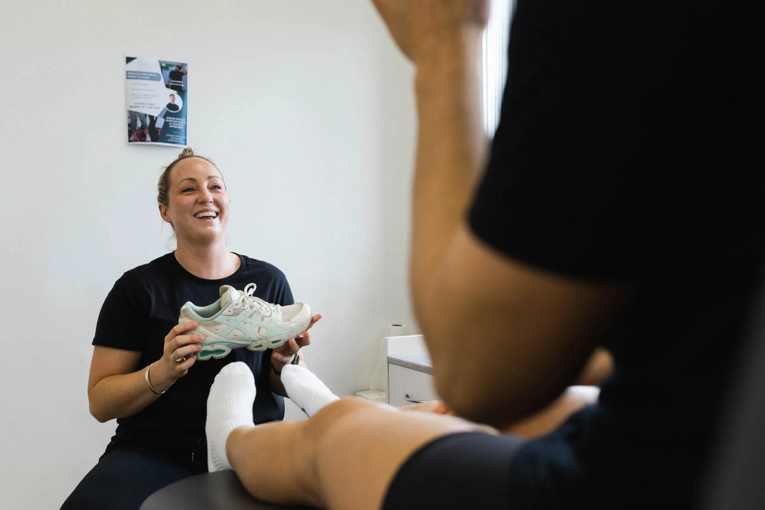 Podiatrist showing a patient their running shoe during a footwear check